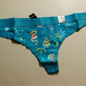 Torrid aqua blue thong panty; pattern includes rose, snake, sun, shell, skull